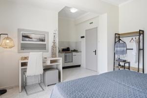 a white bedroom with a desk and a bed at Roys Blu in Kavos +147 photos