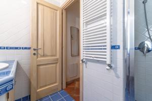 ein Badezimmer mit Holztür und Waschbecken in der Unterkunft Bilo Corallo 2 Palau in Palau