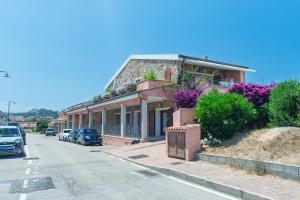 ein Gebäude am Straßenrand mit geparkten Autos in der Unterkunft Bilo Corallo 2 Palau in Palau
