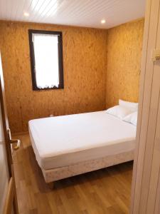 a bed in a room with a window at Chalet confortable à Giffaumont-Champaubert avec terrasse in Giffaumont-Champaubert +5 photos