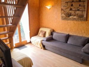 a living room with a couch and a bed at Chalet confortable à Giffaumont-Champaubert avec terrasse in Giffaumont-Champaubert