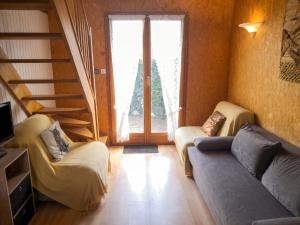 a living room with two chairs and a couch and a window at Chalet confortable à Giffaumont-Champaubert avec terrasse in Giffaumont-Champaubert