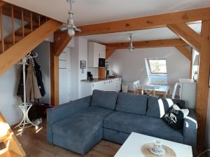 a living room with a blue couch and a kitchen at Baltic Sea in Jastarnia