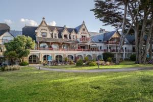 a large house with a large grass yard at Résidence Pierre & Vacances Premium Le Domaine de Cramphore in Le Pouliguen