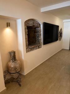 a living room with a fireplace and a tv at Villa Brodetto, Sveti Stefan in Pržno