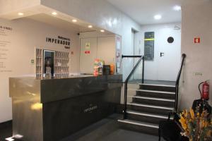 a lobby with a staircase leading to a store at Imperador Hotel in Lisbon