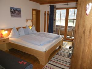 a bedroom with a bed with white sheets and a window at Lindenhof in Kitzbühel