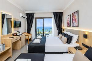 a hotel room with a large bed and a desk at World Star Beach Resort & Spa in Alanya