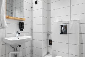 ein weißes Badezimmer mit Waschbecken und Dusche in der Unterkunft Hotel Hötorget, BW Signature Collection in Stockholm + 82 Fotos