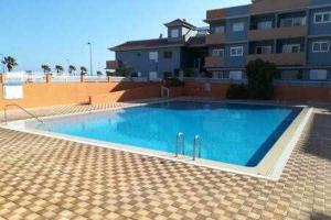 a large blue swimming pool in front of a building at Casas Galloway - Puertito Güímar. Sol y comodidad. in Puertito de Güímar