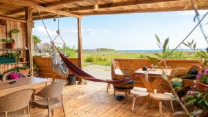 a hammock on a deck with tables and chairs at Ćićkova Čarda in Ulcinj
