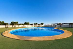 a large swimming pool on a grass field at Kampaoh Roquetas in Roquetas de Mar