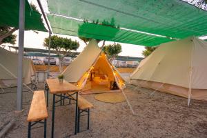 a group of tents with a table and chairs in front at Kampaoh Roquetas in Roquetas de Mar