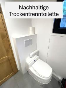 a white toilet in a bathroom with the wordskniferoleitschidate at Tiny House am Ranziger See in Tauche +39 photos