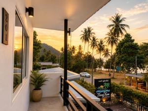 a balcony with a view of a street and palm trees at Nangkam Boutique Donsak in Ban Pheng Krong