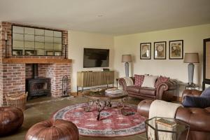 a living room with a couch and a fireplace at Rosehaven House at Pudleston Court in Docklow
