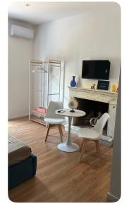 a living room with a table and chairs and a fireplace at Sanleucio SILK ROOM in Caserta