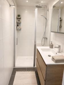 a white bathroom with a shower and a sink at Noordwijk BB228 in Noordwijk +11 photos