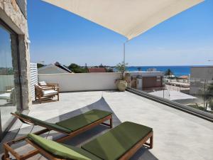 a patio with chairs and a view of the ocean at Elaia Rooms in Noto Marina