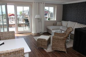 a living room with a couch and a table and chairs at Hafenresidenz Fehmarn in Lemkenhafen auf Fehmarn
