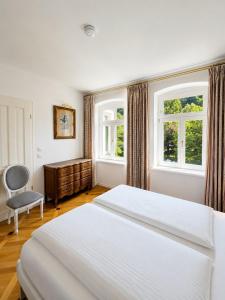 a bedroom with two beds and a desk and two windows at Apartmenthaus Albrechtsburg in Bad Schandau