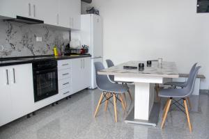 a kitchen with a white table and chairs at Motel Nova in Strumica