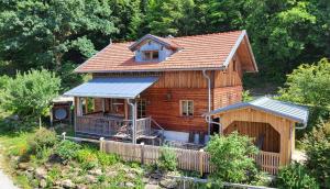 a log cabin with a porch and a roof at Sunleitn Ferienhäuser am Waldrand in Geiersthal