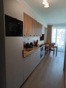 a kitchen with a refrigerator and a dining room at Apartament 512 in Dziwnówek