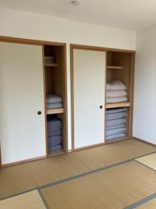 two closets with doors in a room with towels at Ocean view Private Hotel in Shimoda
