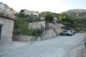 a car parked next to a stone wall at Agora Apartments in Dhërmi