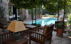a patio with a table and chairs next to a pool at L’Hort de Sant Cebrià in Torroella de Fluviá