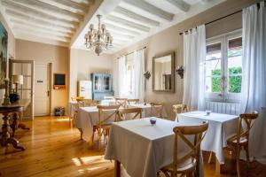a dining room with tables and chairs and a chandelier at L’Hort de Sant Cebrià in Torroella de Fluviá