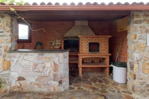 an outdoor kitchen with a stone wall and a stove at Pensión Casa Felisa in Monforte de Lemos