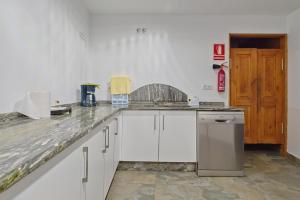 a kitchen with white cabinets and a counter top at Pensión Casa Felisa in Monforte de Lemos