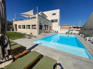 a swimming pool in front of a house at Elaia Rooms in Noto Marina