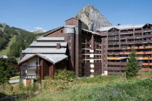 a large building with a mountain in the background at Résidence Pierre & Vacances La Daille in Val-d'Isère