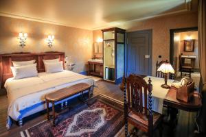 a bedroom with a bed and a desk with a lamp at la maison oubliée in Goetzenbruck