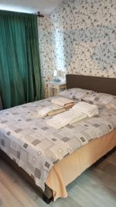 a bedroom with a bed with a white comforter at Green Apartman in Čukarica