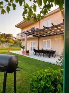 a house with a patio with a table in the yard at Vila CarpeDiem in Herceg-Novi