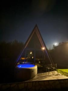 a pyramid house with a swimming pool at night at TriView in Žabljak