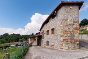 a large stone building with a red roof at Pensión Casa Felisa in Monforte de Lemos