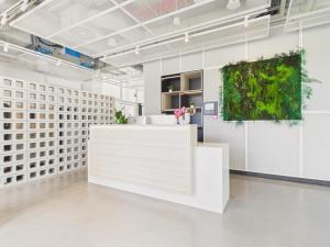 a white reception area in a white room with plants at NanoApart by Solarento in Warsaw