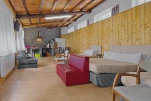 a bedroom with two beds and a red chair at Vivienda Jardin in Monforte de Lemos