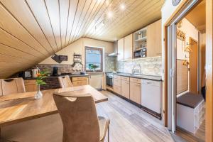 a kitchen with a wooden ceiling and a table and chairs at Bassd scho in Ebensfeld