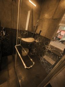 a bathroom with a glass shower with a bucket at TGC Resort And Hotel Arpora in Calangute +22 photos