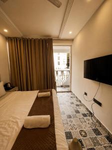 a hotel room with a bed and a flat screen tv at TGC Resort And Hotel Arpora in Calangute