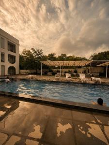 a large swimming pool next to a building at TGC Resort And Hotel Arpora in Calangute