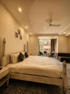 a bedroom with a large bed and a window at TGC Resort And Hotel Arpora in Calangute