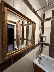 a bathroom with a mirror and a sink at 3 комнатные апартаменты in Karagandy