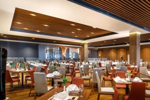 a restaurant with tables and chairs in a room at Remisens Casa Rosa, depandansa hotela Metropol in Portorož
